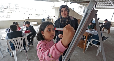 Enkazdan kurtulan Sibel öğretmen terasta hazırladığı sınıfta öğrencilere eğitim veriyor